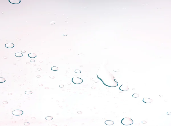 Gota de agua y gotita sobre espejo brillante fondo blanco y azul — Foto de Stock