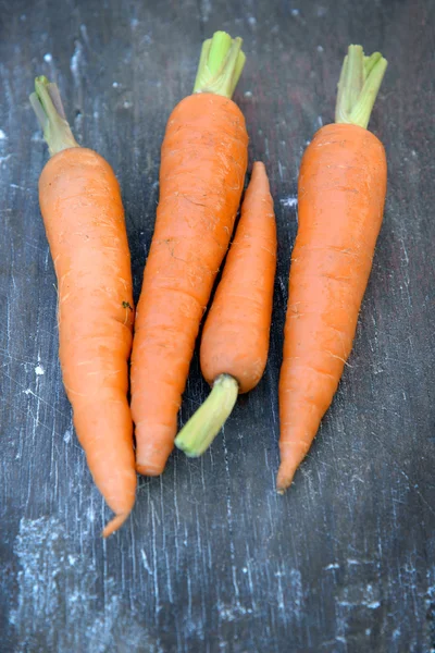 Carottes biologiques fraîches sur fond en bois — Photo