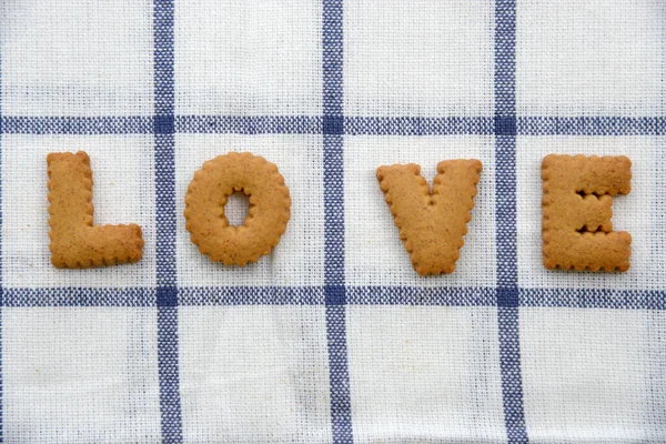 Kelime "aşk" masa örtüsü üzerinde formunda bisküvi. — Stok fotoğraf