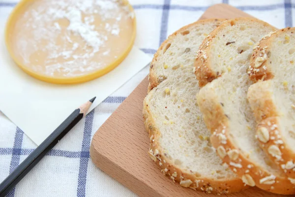 Pão branco fatiado em chapa de madeira — Fotografia de Stock