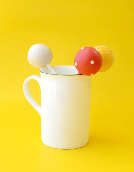 Sucette en tasse blanche, sur fond jaune — Photo