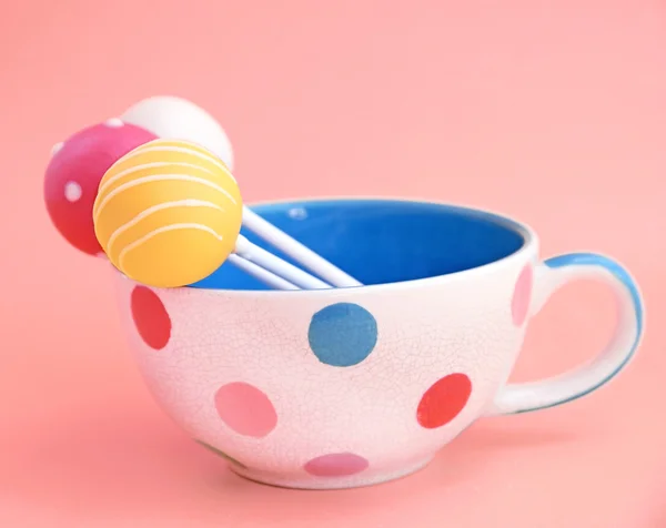 Cake pops decorated in cup on pink background — Stock Photo, Image