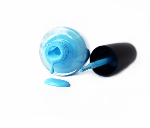 Blue nail polish bottle with splatters isolated on white background — Stock Photo, Image