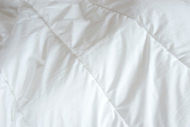 Dağınık yatak, beyaz battaniye arka planı için.