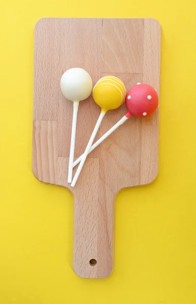 Tasty cake pops on wooden plate. — Stock Photo, Image