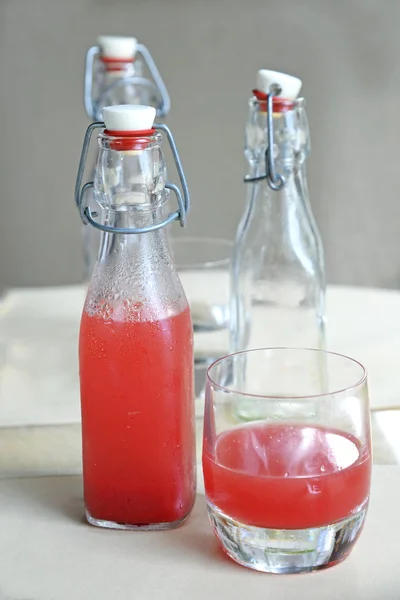 Jugo de sandía en botella de vidrio en la mesa — Foto de Stock