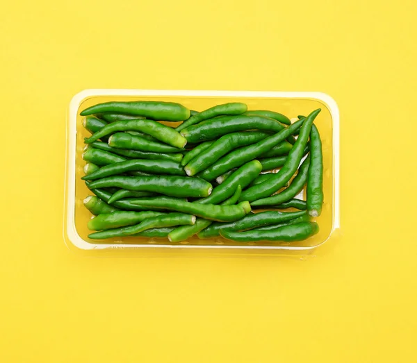 Green hot peppers on yellow (pop art style) — Stock Photo, Image