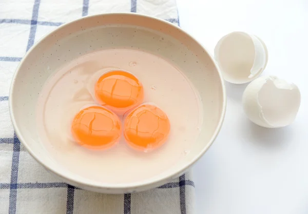 Tres yorks de huevo con cáscara de huevo en mantel — Foto de Stock