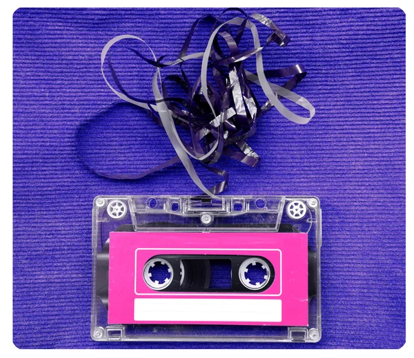 Audio cassette tape met afgetrokken uit tape over blauw ribbels en noppen — Stockfoto