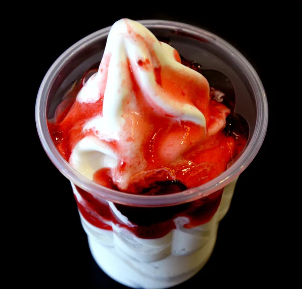 Milk icecream with strawberry sauce in takeaway cup on black background — Stock Photo, Image