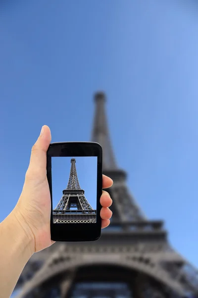 女性の携帯電話では、エッフェル塔の写真を撮影. — ストック写真