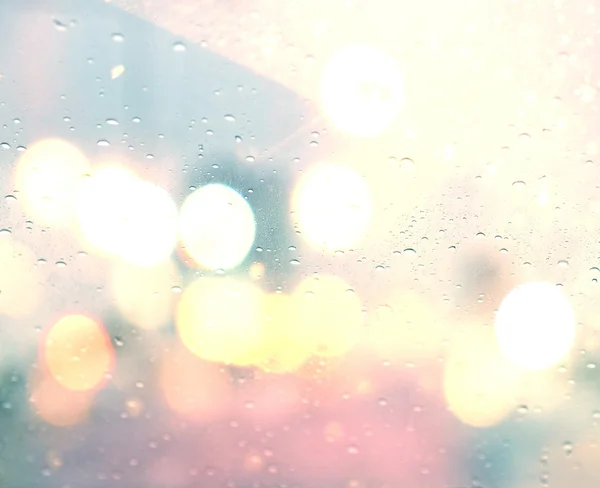 Gotas de lluvia sobre fondo de vidrio. Calle bokeh luces fuera de foco. —  Fotos de Stock