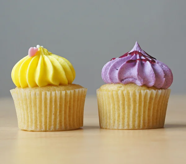 Dos cupcakes de vainilla con crema dulce encima —  Fotos de Stock
