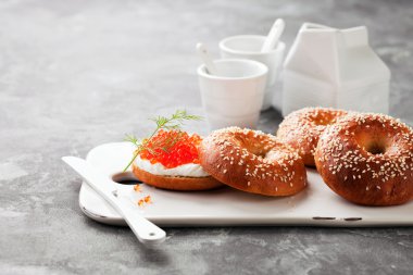 Taze ev yapımı simit sandviç krem peynir ve seramik yönetim kurulu hizmet üzerinde kırmızı havyar ile