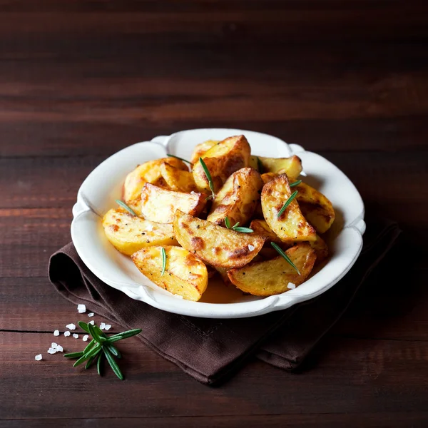 Roasted potato wedges with rosemary on plate — Stock Photo, Image