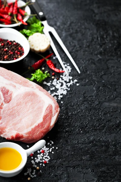Φρέσκο νωπό χοιρινό κρέας και τα υλικά για το μαγείρεμα σε μαύρο φόντο — Φωτογραφία Αρχείου