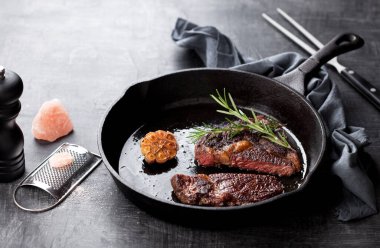 Roasted beef ribeye steak in a cast iron frying pan, a selective focus clipart