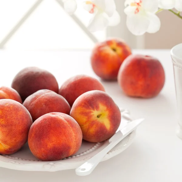 Verse rijpe perziken op een bord — Stockfoto