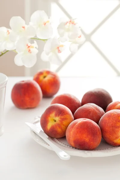 Verse rijpe perziken op een bord — Stockfoto