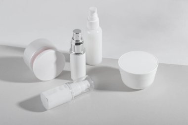 Beyaz kozmetik şişeler ve sert gölgeli kavanozlar. Ev ve güzellik salonu konsepti