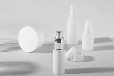 Beyaz kozmetik şişeler ve sert gölgeli kavanozlar. Ev ve güzellik salonu konsepti