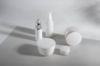 Beyaz kozmetik şişeler ve sert gölgeli kavanozlar. Ev ve güzellik salonu konsepti