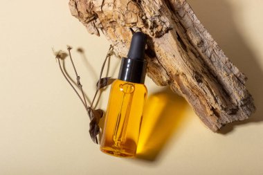 Sauna ve spa için kozmetik seti. Ahşap bir standın üzerinde doğal vücut ve saç yağı olan şeffaf cam bir kap. Düzen tasarımı. Kozmetik ve güzellik kavramı.