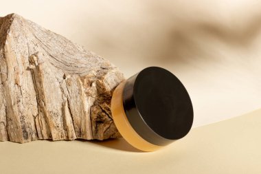 Yüz ve vücut için krem ya da maskeli kozmetik kavanozu, kütük ve sert gölgelerle dolu bir arka plana karşı. Güzellik salonu ve doğal kozmetik ürünleri konsepti.