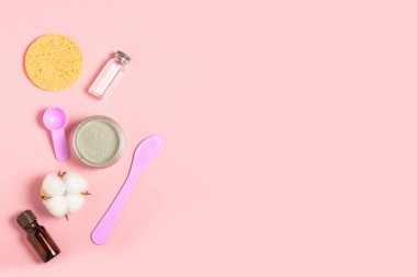 Krem ya da kozmetik maske ve aksesuarlı kozmetik kavanoz. Arındırıcı ve nemlendirici bir kil maske. Üst manzara, düz uzanma