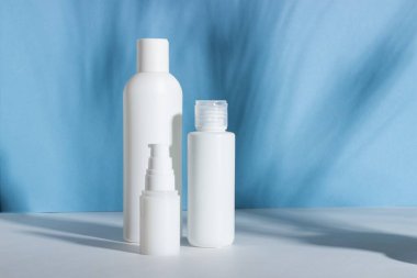 Beyaz kozmetik şişeler ve sert gölgeli kavanozlar. Ev ve güzellik salonu konsepti