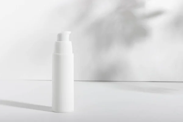 White cosmetic tube on a white background with shadows. Nourishing and moisturizing face cream, hand cream or lotion. Womens cosmetic tube with a skin care product.