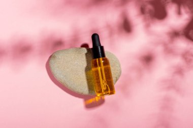 Serum şişesi, arka planda gölgeler olan temel kozmetik yağı. Kozmetik spa ürünü ve pipette. Bronzlaşma yağı