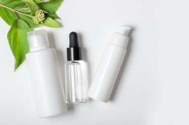 Doğal malzemeli kadın kozmetikleri. Yüz ve vücut bakımı için. Beyaz arka planda taze otlarla birlikte çevre dostu yüz kremi tüpü. Boşluğu, düzeni kopyala