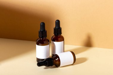 Serum ve temel kozmetik yağ şişesi. Arka planda gölgeler var..