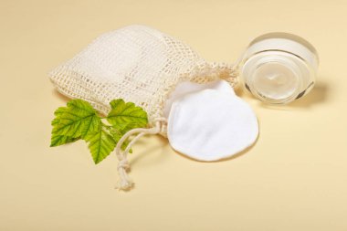 Bej bir arka planda bez bir çantada pamuk çıkarılabilir makyaj çıkarıcı pedler. Ekoloji ve bilinçli tüketim kavramı. Yeniden kullanılabilir pamuk pedleri