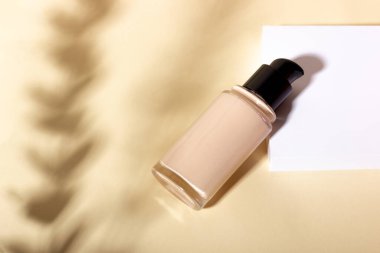 Şişedeki sıvı temel geometrik şekillerin arka planına karşı.