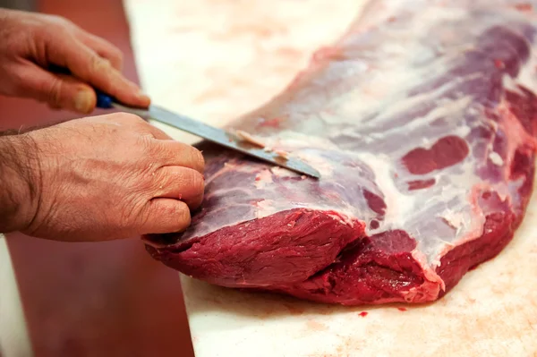 Primer plano del carnicero cortando carne — Foto de Stock