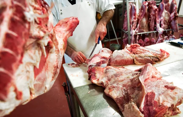 Carnicero cortando trozos de carne — Foto de Stock