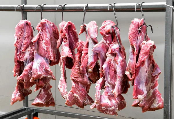 Carne roja fresca colgando de ganchos metálicos — Foto de Stock