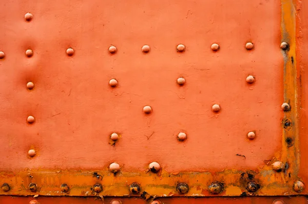 Alte verblasste rote Metallhintergrund mit Nieten — Stockfoto