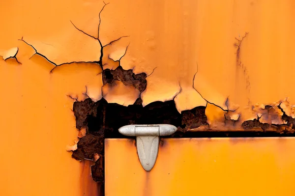 Old rusty hinge detail of orange metal door — Stock Photo, Image