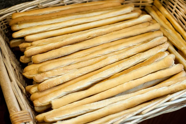 Bastoncini di pane appena sfornati in un cesto di vimini — Foto Stock