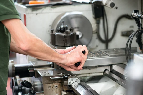 Blue collar or skilled labor working on a lathe — Stock Photo, Image