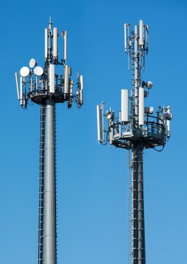 Two telecommunications towers with satellites clipart
