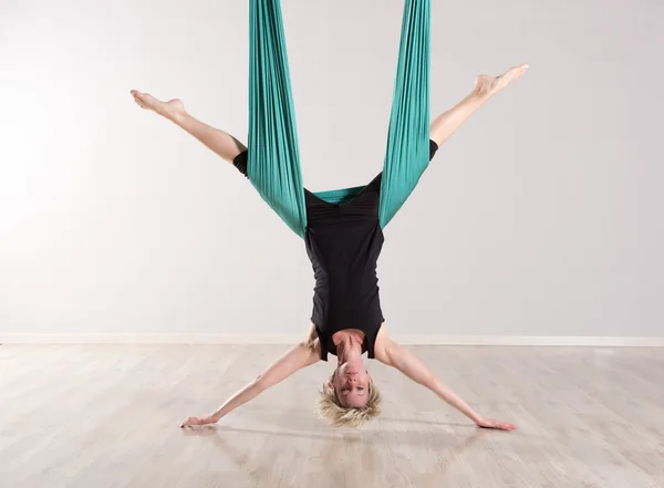 Única mulher de cabeça para baixo fazendo divisões aéreas de ioga — Fotografia de Stock