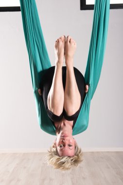 Woman hanging upside down in aerial yoga tarp