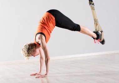 Woman on hands with training rings around feet