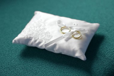 Aşk ve romantizmi sembolize eden evlilik töreninden önce küçük dekoratif beyaz bir yastıkta iki altın alyans sergilendi.