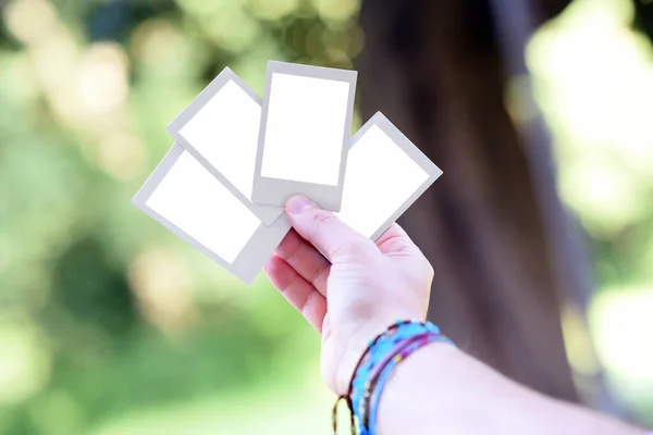 Hand Holding Four Blank Instant Photo Frames Fanned Out Outdoor — Stock Photo, Image