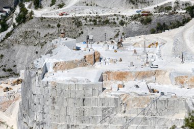 Carrara, Tuscany, İtalya 'daki mermer taş ocağı vadisine bakın. Kesik taş blokları ve açık madenlerde teraslı kaya yüzeyi görünüyor.